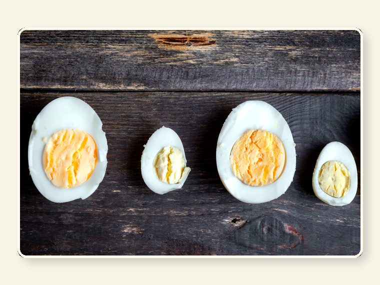 Boiled Eggs Cut Half Dark Wooden Background Top View — healthy food and nutrition support for rescued primates and sanctuary animals.